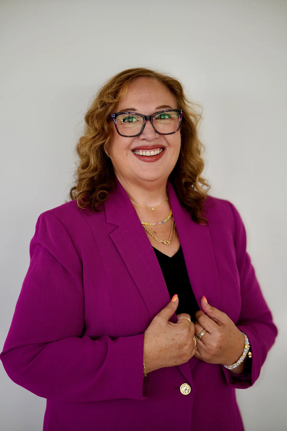 Jessica Hernandez smiling in a magenta suit